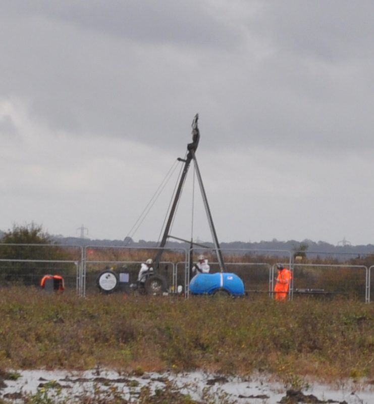 Lower Thames Crossing Ground Investigation Site Visit. Ground Investigation workers in a field working with a tripod style drilling rig